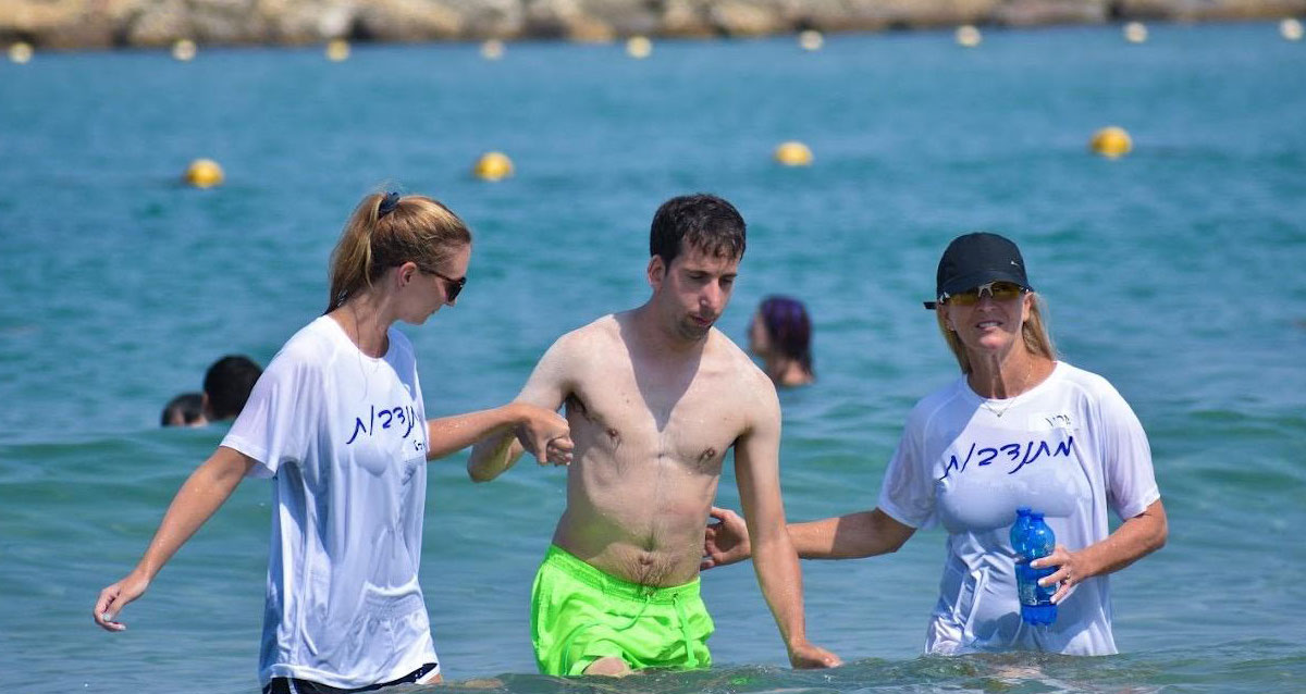 הנגשה בחופי תל אביב - מתנדבים מבלים בים עם בעלי מוגבלויות. צילום: דור בן טובים