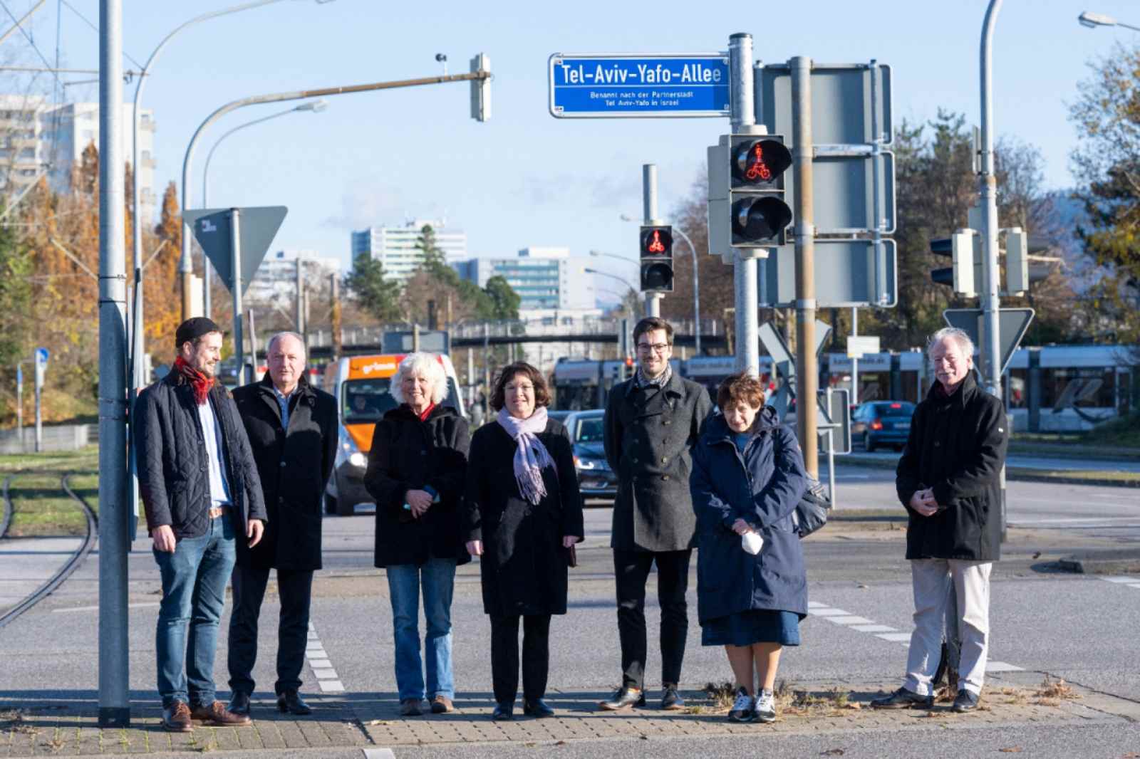 אנשים עומדים ליד שלט רחוב שדרת תל אביב יפו בפרייבורג גרמניה