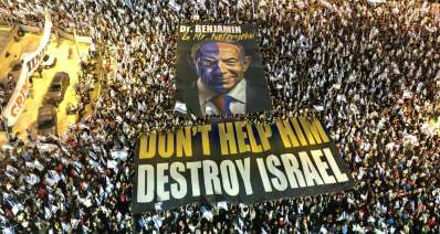 קפלן. הפגנה נגד המהפכה המשפטית. דגל פריסה DON'T HEL HIM DESTROY ISRARL. צילום רחפן