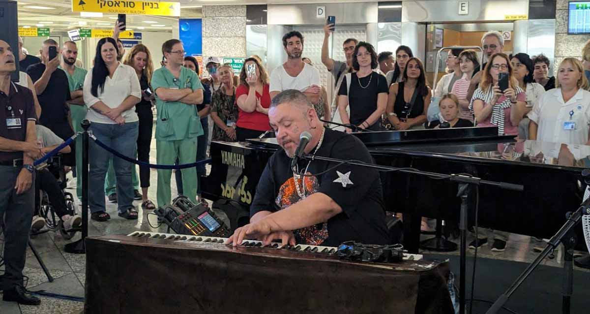 ארקדי דוכין מנגן ושר באיכילוב. לידו רוני גמזו מנכ"ל בית החולים, חולים ובני משפחותיהם ואנשי צוות