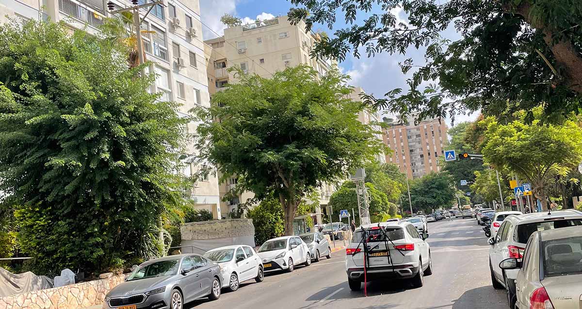 שכונת נווה אביבים, רחוב עם בניינים בצד שמאל ועצים במדרכה. בשני הצדדים של הרחוב חונות מכוניות במקביל למדרכה. מכונית נוסעת באמצע הכביש.