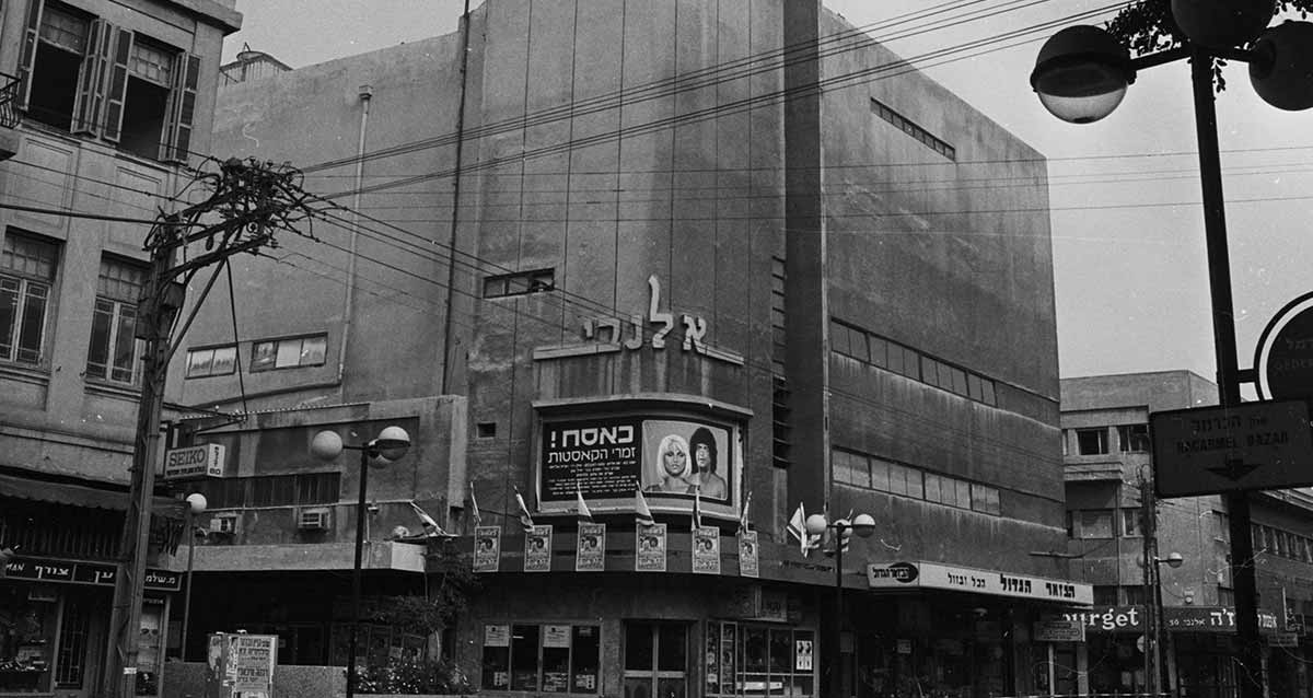 קולנוע אלנבי בשנת 1974. בפינה של הבניין פרסומת לסרט: כאסח ! זמר הקסטות, ותמונה של זמר וזמרת. בצד ימין של הבניין חנות בשם: הבאזר הגדול הכל ובזול. בצד שמאל בבניין סמוך חנות של שען וצורף.