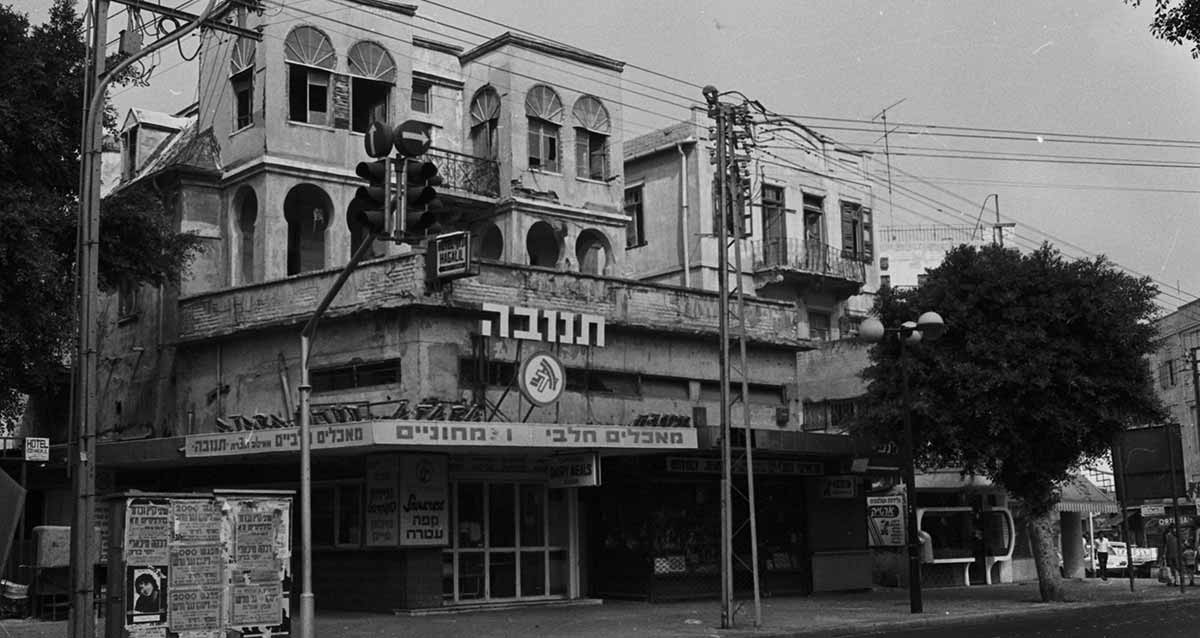 בית שלוסברג ברחוב אלנבי ומלון הגליל ב-1974. בניין בן 4 קומות. בקומת הקרקע חנות של מאכלים חלביים צמחוניים, וסמל ושלט של תנובה בקומה השנייה.