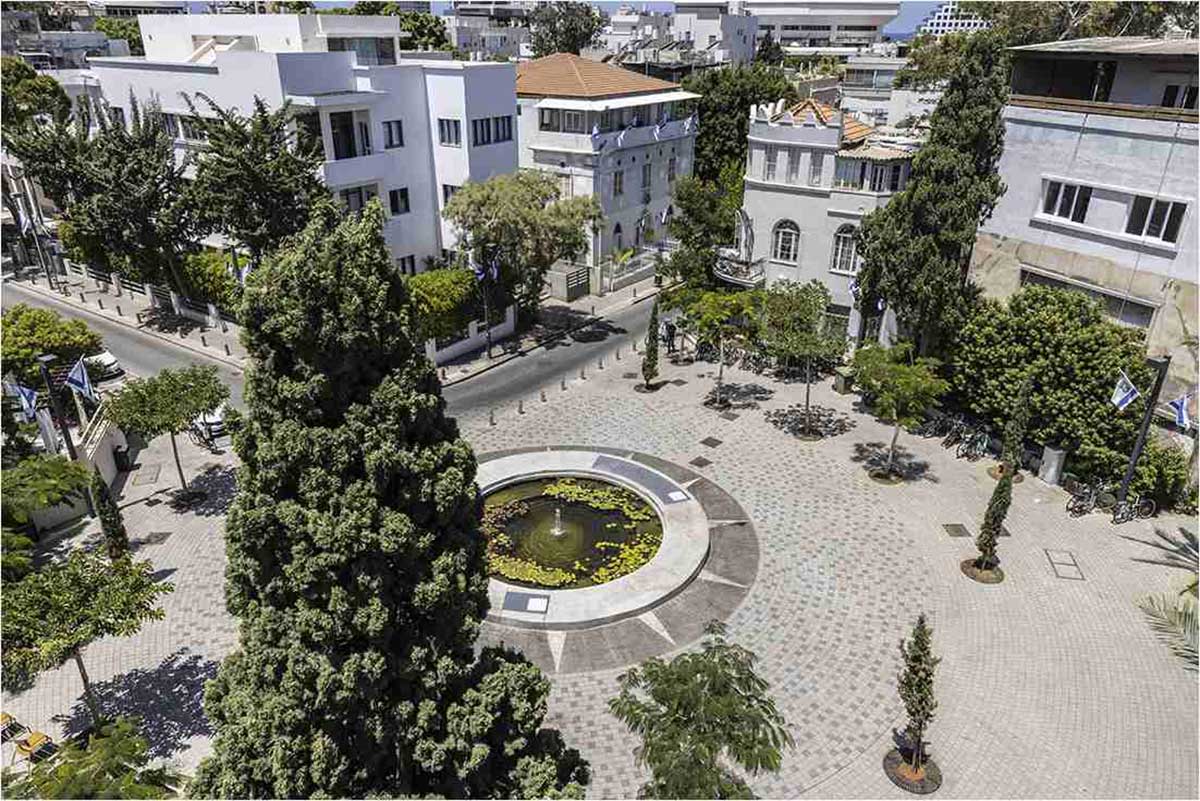 כיכר ביאליק. צילום מעל הכיכר. בכיכר בריכת מים עם צמחי מים. מסביב לכיכר בתים ועצים גבוהים.