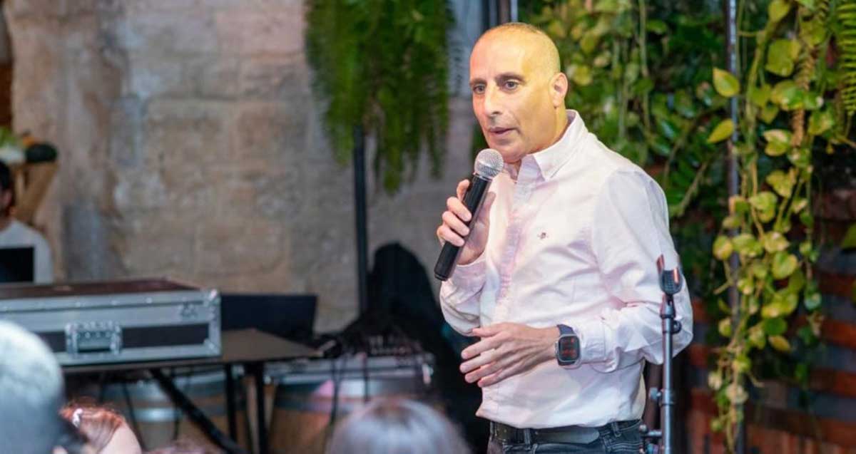 גל שרעבי דמאיו עם מיקרופון בידו, מול קהל.