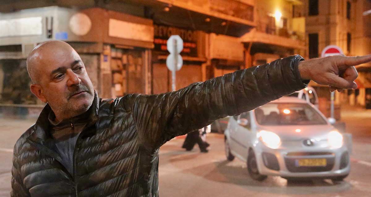 סיור קולינארי בתל אביב. המדריך מצביע ביד כלפי מעלה.