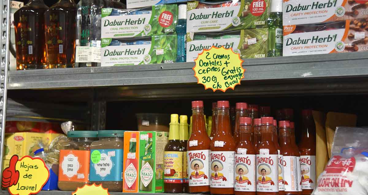 המכולת הלאטינית לה טיינדה בת"א. מדפים מלאים במוצרים, בקבוקים, צנצנות, ואריזות קרטון.